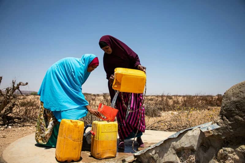 Women in Somaliland pouring water into water tanks