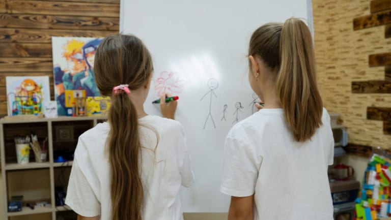 Two girls drawing in the ActionAid Safe Space for children