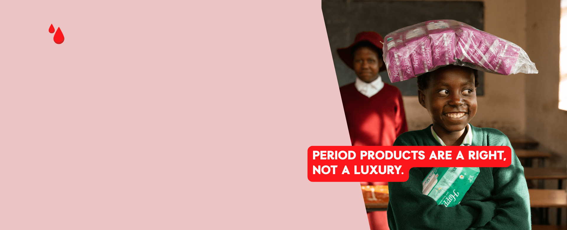 A smiling schoolgirl standing in a classroom, proudly holding menstrual pads — representing access to period products and the power of education.
