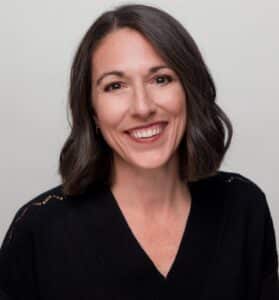 Emily Bracken, an ActionAid Board Member, has dark hair and eyes and pale skin. 