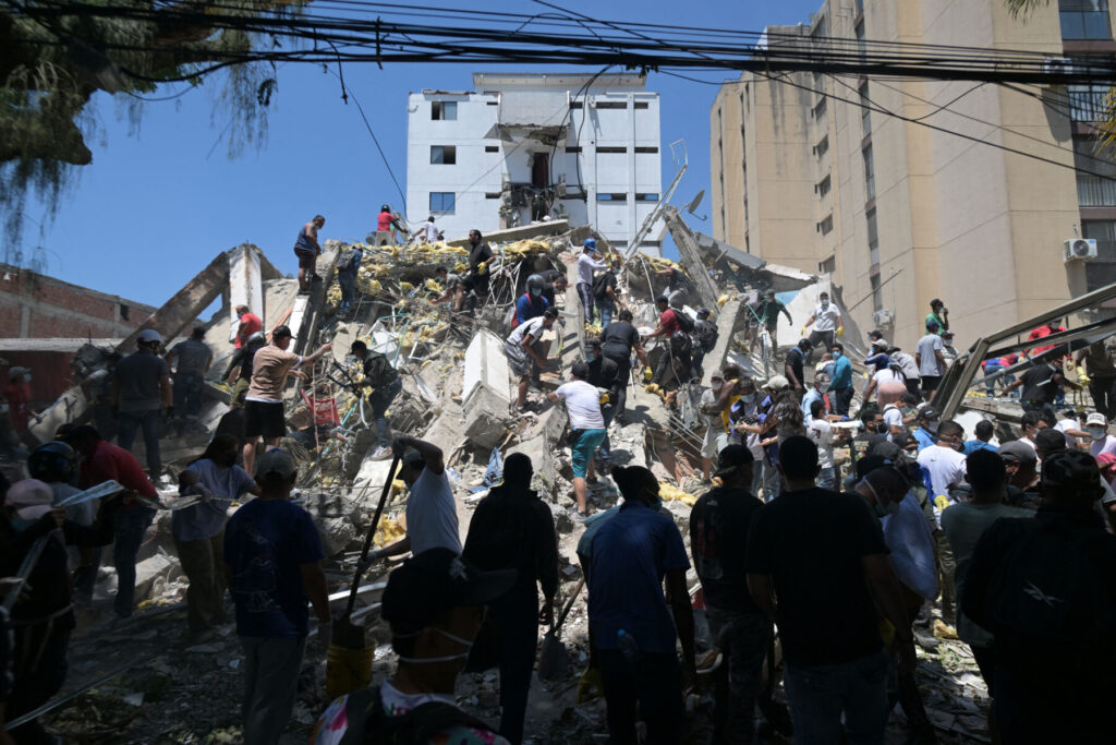 People carrying out rescue efforts on top of a building destroyed by the earthquake in Colombia.